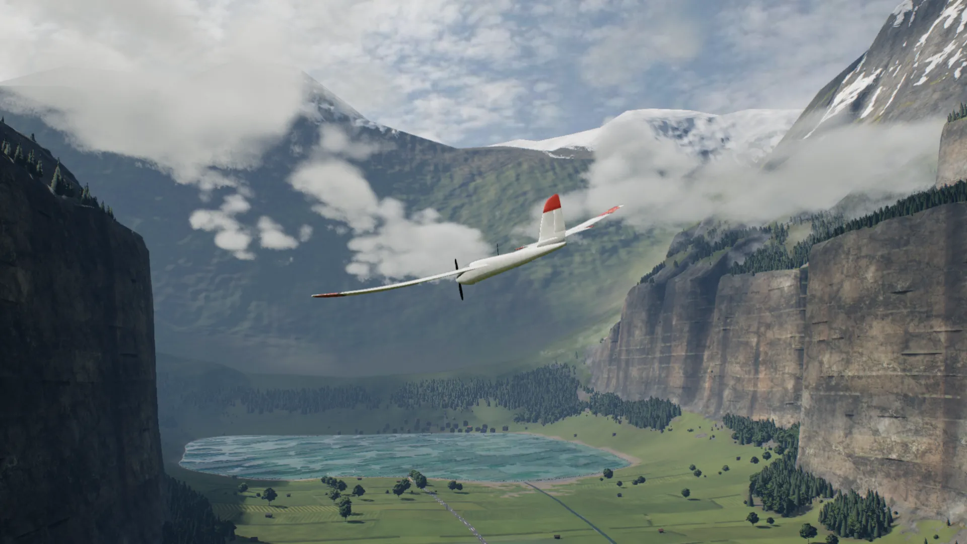 An RC glider high over the valley, its lake below
