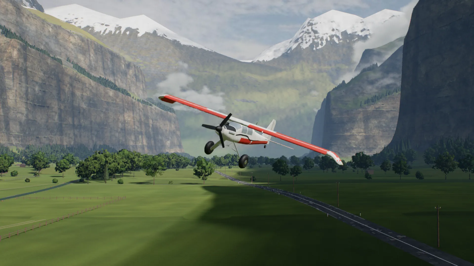 A red and white RC trainer banking toward the camera low over the valley floor, snowy peaks behind